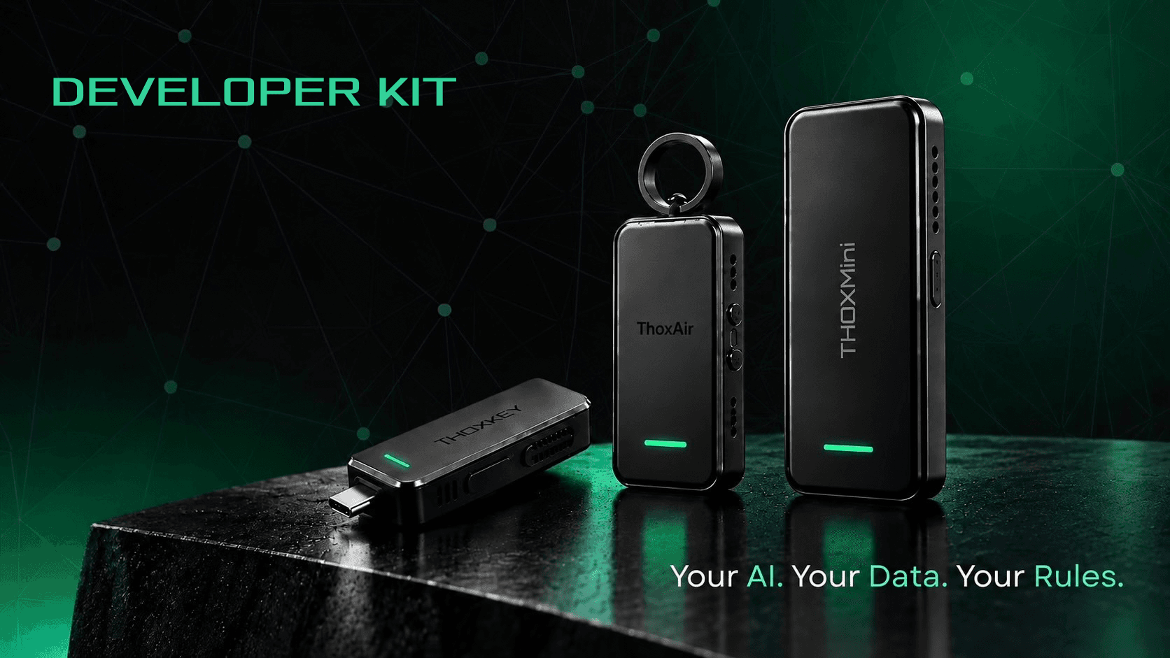 Developer Kit graphic, titled DEVELOPER KIT in green capitals at the top left. The three Developer Kit devices in Matte Black stand on a wet dark ledge against a green-lit backdrop patterned with faint network nodes: a ThoxKey resting on its side with its USB-C connector forward, a ThoxAir standing upright on its keyring loop, and a ThoxMini beside it carrying the vertical THOXMini mark. Each shows a lit green status bar and reflects in the ledge. The THOX tagline Your AI. Your Data. Your Rules is set into the lower right.